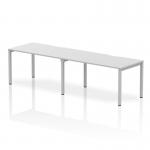 The photograph shows a sleek and modern Dynamic Bench Desking Evolve Plus desk. It is 1400mm in length and can accommodate two people in a single row. The desk has a white top and a silver frame, giving it a clean and contemporary look.