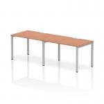 The photo showcases a sleek and modern Dynamic Bench Desking Evolve Plus 1200mm Single Row 2 Person Office Bench Desk. The beautiful beech top is supported by a sturdy silver frame, creating a stylish and functional workspace for two people.