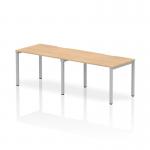 This photograph showcases a sleek and modern Dynamic Bench Desking Evolve Plus desk. The maple top and silver frame add a touch of elegance, while the single row design makes it perfect for two individuals to work comfortably side by side.