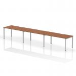 This photo captures a sleek and modern workspace with the Dynamic Bench Desking Evolve Plus 1600mm Single Row 3 Person Office Bench Desk. The walnut top and silver frame create an elegant yet functional design, perfect for any office setting.