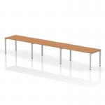 The image shows a dynamic bench desking set-up featuring the Evolve Plus 1600mm single row desk, designed to accommodate 3 people in an office. The desk has a sleek oak top and is supported by a silver frame.