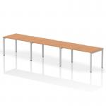 The Dynamic Bench Desking Evolve Plus 1400mm Single Row 3 Person Office Bench Desk features a sleek and modern design with an oak top and silver frame. The spacious workspace comfortably accommodates three people and promotes a collaborative work environment.