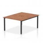 A photo of the Dynamic Bench Desking Evolve Plus 1200mm B2B 2 Person Office Bench Desk shows a sleek and modern design. The desk features a walnut top and black frame, creating a stylish contrast. Perfect for a collaborative work environment, this desk offers functionality and sophistication.