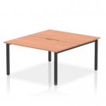 This photograph features a sleek and modern 1400mm dynamic bench desking setup, specifically designed for two people. The desk has a beech top and a black frame, creating a professional and contemporary look.