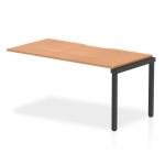 The photograph showcases the sleek and modern design of the Dynamic Bench Desk Add On Units Evolve Plus 1600mm Single Row Office Bench Desk Ext Kit. The oak top and black frame create a sophisticated and professional look, perfect for any office space.