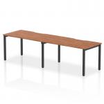 This photograph features the Dynamic Bench Desking Evolve Plus 1400mm Single Row 2 Person Office Bench Desk with a walnut top and black frame. The clean, sleek design allows for a modern and efficient workspace.