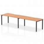 This photo features a 1600mm single row 2-person office bench desk from the Evolve Plus collection, with an oak top and black frame. The dynamic design of this bench desking creates a modern and professional workspace.