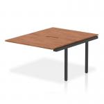 The photograph shows a sleek and modern Dynamic Bench Desk with Add On Units, measuring 1200mm. The desk is made of walnut top and has a black frame. This office bench desk is part of the Evolve Plus collection, perfect for any B2B setting.