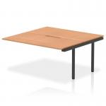 The photograph captures a sleek and modern office environment with the Dynamic Bench Desk Add On Units Evolve Plus. The 1600mm B2B Office Bench Desk Ext Kit features an elegant oak top and stylish black frame, creating a professional and sophisticated workspace.