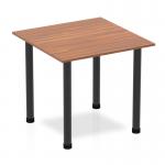 This image features a stylish Dynamic Tables Impulse 800mm square table with a rich walnut top and sleek black post legs. The design exudes modernity and sophistication, making it a great addition to any space.