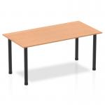 The photograph shows a stylish and modern Dynamic Tables Impulse 1600mm Straight Table with an oak top and black post legs. The clean lines and sleek design give a professional and contemporary look. Perfect for any office or workspace.