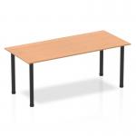 The picture shows a sleek and modern Dynamic Tables Impulse 1800mm Straight Table with an oak top and black post leg. The table has a clean and minimalist design, perfect for any contemporary office or workspace.