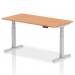 This photo showcases a sleek and modern office desk with a 1600 x 800mm oak top and silver legs. The desk is adjustable in height, allowing for both sitting and standing positions. The dynamic design adds versatility and functionality to any workspace.
