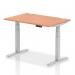 The photograph shows a modern office desk made of beech wood, with a silver adjustable leg. It has a spacious 1200 x 800mm top and cable ports for easy organization. The desk is also height adjustable, allowing for a comfortable sit-stand work experience.