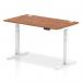 This picture features a sleek 1400 x 800mm walnut top desk with white adjustable legs. The desk is designed to easily switch between sitting and standing positions for a more dynamic work experience. It also includes convenient cable ports for a clutter-free workspace.