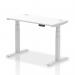 This photo shows a modern and versatile office desk in white, with a smooth top and sleek silver legs. The desk is equipped with cable ports and can be easily adjusted in height, providing a comfortable and ergonomic workspace for any user.