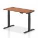 This image showcases our dynamic sit stand and height adjustable desks. The desk measures 1200 x 600mm and features a walnut top with cable ports, supported by black legs. It is perfect for any office space, providing versatility and functionality.