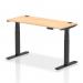 This photo shows a spacious and modern office desk with a sleek maple top and black legs. The desk is equipped with a dynamic sit-stand feature, allowing for easy height adjustment. It also features cable ports for a neat and organized workspace.