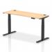 The image shows a sleek and modern 1600 x 600mm dynamic sit stand and height adjustable desk in a maple wood finish. It features built-in cable ports for a tidy workspace and is supported by sturdy black legs. This versatile office desk allows for effortless transitions between sitting and standing for ergonomic comfort.