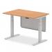 The picture shows a modern office desk with a 1200 x 800mm oak top. Its silver legs are adjustable for sit stand positions, with a matching silver steel modesty panel. This desk is designed for a dynamic and ergonomic work environment.
