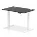 This image shows a modern office desk with a sleek black top and white adjustable legs. The desk has a spacious 1200 x 800mm surface and features cable ports for easy organization. Its dynamic sit stand function allows for customizable height adjustment.