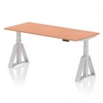 The photo shows a spacious office desk, measuring 1800 x 800mm, featuring a dynamic sit stand and height adjustable design. The top is made of beech wood, while the legs are silver in color, and the feet are piste-shaped. The desk is ideal for creating a comfortable and ergonomic workspace.