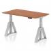 The picture shows a sleek and modern height adjustable desk in a beautiful walnut finish with a silver leg and piste foot design. The desk has a spacious 1400 x 800mm surface, perfect for a dynamic sit-stand workspace. Its adjustable feature allows for customizable height to accommodate different preferences and needs. Ideal for any office setup.