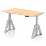 The picture shows a compact and modern office desk measuring 1400 x 800mm, with a sleek maple top and silver adjustable legs. The desk also features a dynamic sit-stand function and a piste foot for added comfort. Perfect for creating a versatile and ergonomic work space.