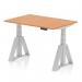 This photograph showcases a sleek and modern dynamic sit stand desk, featuring a spacious 1200 x 800mm oak top and adjustable height for comfortable sitting or standing. The silver legs and piste foot add a touch of sophistication to any office space.