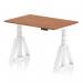 This photograph features a sleek and functional Dynamic Sit Stand and Height Adjustable Desk. The desk has a beautiful walnut top and white legs, with a Piste Foot for added stability. Its compact size of 1200 x 800mm makes it perfect for any office space.
