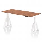 This photo showcases a sleek and modern dynamic sit-stand desk. It features a spacious 1800 x 800mm walnut top, white legs, and a convenient piste foot for added support. The height is easily adjustable for a comfortable and ergonomic workspace.