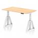 The picture shows a dynamic sit-stand desk with a height-adjustable feature, measuring 1400 x 800mm. The desk has a maple top and white legs with a piste foot, giving it a modern and minimalist look. It would be suitable for any office setting.
