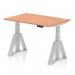 The photograph shows a sleek and modern office desk with a 1200 x 800mm beech top and silver legs. The desk is height adjustable and features cable ports and a piste foot for added convenience. The dynamic sit stand design allows for versatile use throughout the workday.