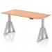 The image shows a sleek and modern height adjustable office desk with a beech top and silver legs. The desk features cable ports and a Piste Foot for added stability. Its dimensions are 1600 x 800mm and it can easily switch between sit and stand positions for a dynamic work experience.