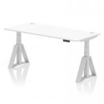 The photo shows a sleek white desk with a silver leg and piste foot, featuring a spacious 1800 x 800mm surface. The desk is height adjustable, allowing the user to switch between sitting and standing positions. Convenient cable ports are also visible on the desks top surface.