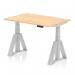The photograph shows a dynamic sit stand and height adjustable desk measuring 1200 x 800mm. The desk features a maple top, cable ports, silver legs, and a piste foot. It can be adjusted to the desired height for maximum comfort and productivity.