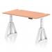 The picture shows a spacious 1400 x 800mm beech top desk, with white adjustable legs and a Piste foot for stability. Cable ports are present for a clean and organized workspace. The desk is height adjustable for sitting or standing, promoting a dynamic and comfortable work environment.