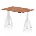 This photograph features a modern and functional office desk. It has a sleek walnut top, white adjustable legs, and cable ports for organization. The addition of a piste foot adds an extra touch of style to this versatile piece of furniture.