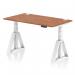 A sleek and modern office desk, the Dynamic Sit Stand and Height Adjustable Desk features a large Walnut top and white adjustable legs. With built-in cable ports and a Piste foot, this desk offers versatility and ergonomic support for any workspace.