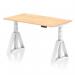 This picture shows a sleek and modern office desk with a maple top and white leg. It features a dynamic sit stand and height adjustable design, measuring 1400 x 800mm. The desk also includes convenient cable ports and a piste foot for added stability.