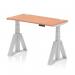 This photograph features a dynamic sit stand and height adjustable desk, measuring 1200 x 600mm. The desk has a sleek beech top and silver leg with cable ports, and is equipped with a piste foot for added stability. Perfect for any office setting.