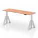 This photo features a dynamic sit-stand and height adjustable desk, measuring 1800 x 600mm. It has a beech top and silver legs with cable ports, and is also equipped with a piste foot for stability. The desk is designed for use in a modern office setting.