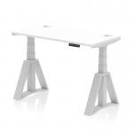 This photograph features a Dynamic Sit Stand and Height Adjustable Desks Air in the dimensions of 1200 x 600mm. The desk has a sleek white top with cable ports and is supported by a silver leg with a piste foot.