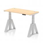 The photograph displays a sleek and modern office desk with dynamic sit-stand and height adjustable features. Its maple top and silver leg give a professional look, while the cable ports provide convenience. The Piste Foot adds stability to the piece.