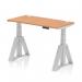 A sleek and modern office desk with an oak top and silver leg. The desk is equipped with height adjustments and cable ports, and features a unique piste foot design. Perfect for a dynamic sit-stand work style.