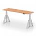 This photo shows a sleek and modern office desk with an oak top and silver legs. The desk is height adjustable and has cable ports for organization. The unique Piste Foot adds a touch of style to this dynamic sit stand desk.