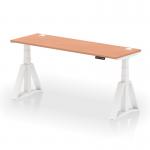 The photo shows a sleek and modern desk with a beech top and white adjustable legs. Cable ports are visible on the surface and a piste foot adds stability. The desk appears to be spacious, ergonomic, and versatile for sitting or standing.