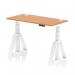 The photo shows a sleek and modern office desk with a 1200 x 600mm oak top and white legs. The desk is height adjustable and features cable ports for organization. The unique piste foot design adds an extra touch of style to this dynamic sit-stand desk.