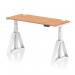 This picture shows a sleek and modern dynamic sit stand and height adjustable desk. The desk has a 1400 x 600mm oak top and white legs with piste foot. It also has convenient cable ports for organization.
