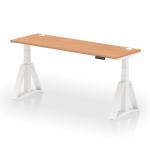 The photo features a sleek and modern Dynamic Sit Stand and Height Adjustable Desk with an oak wood top and white legs. The desk measures 1800 x 600mm and includes built-in cable ports for organization. The Piste Foot provides further flexibility and support for the user.